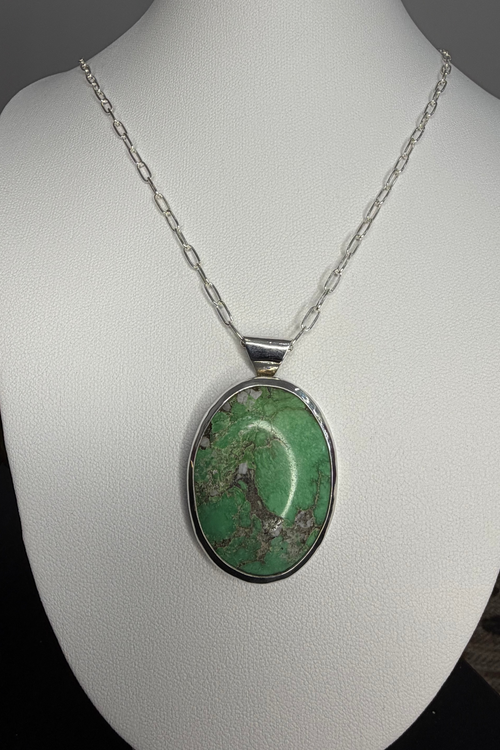Green stone set in sterling silver. Displayed on mannequin.